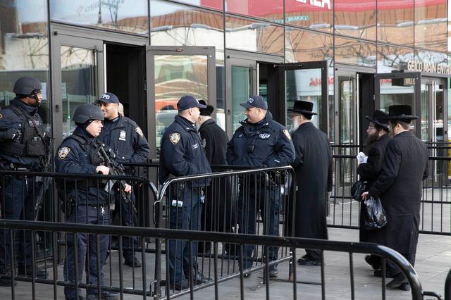 Police stand guard as people arrive at Barclays Center to participate in a reading of the Babylonian Talmud, in Brooklyn, N.Y.